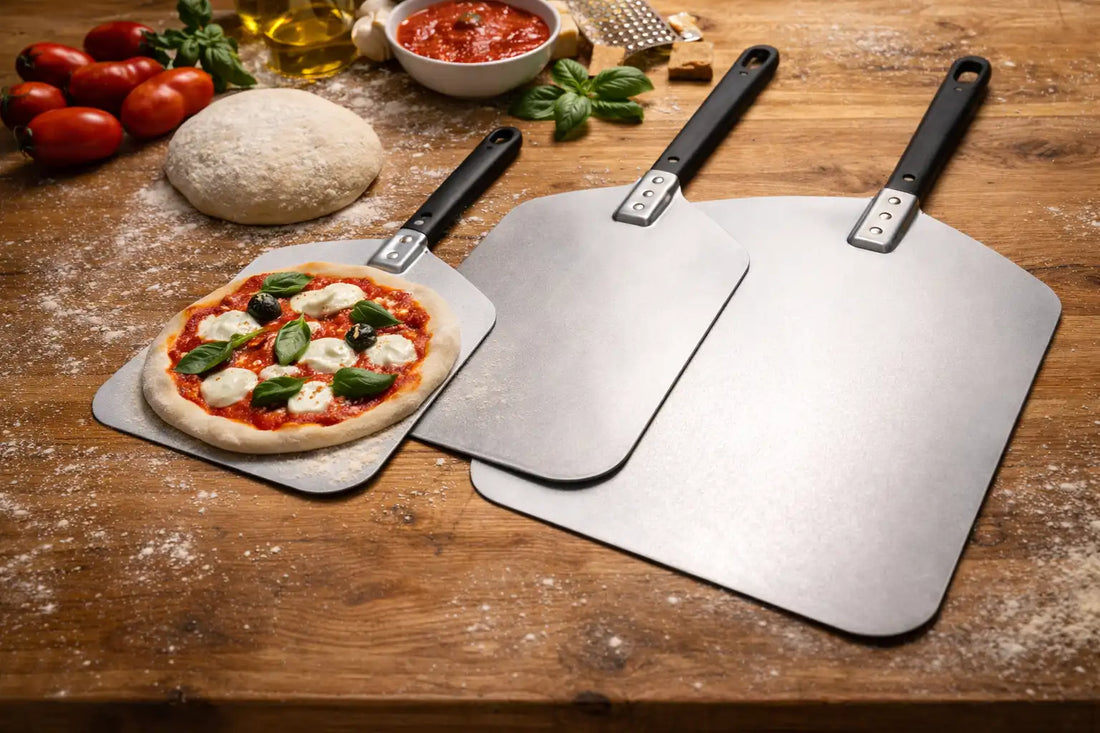 plusieurs pelles à pizza à différentes tailles posées sur la table